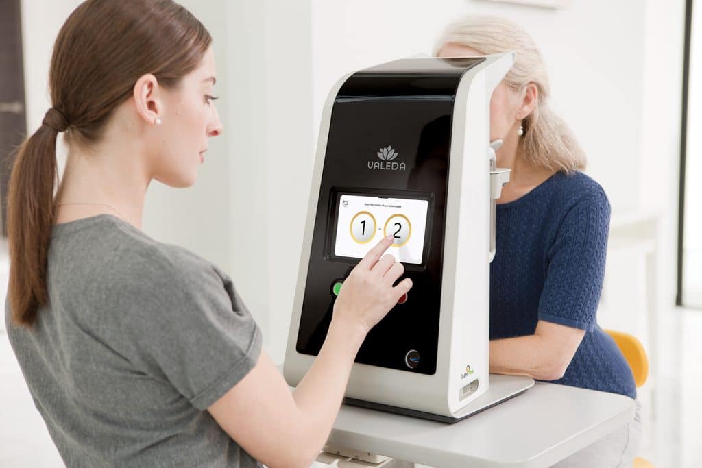 Photo of technician using the Valeda Light Delivery System on a dry AMD patient