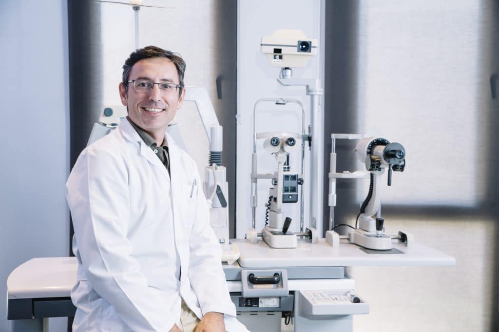 Eye doctor smiling in an exam room
