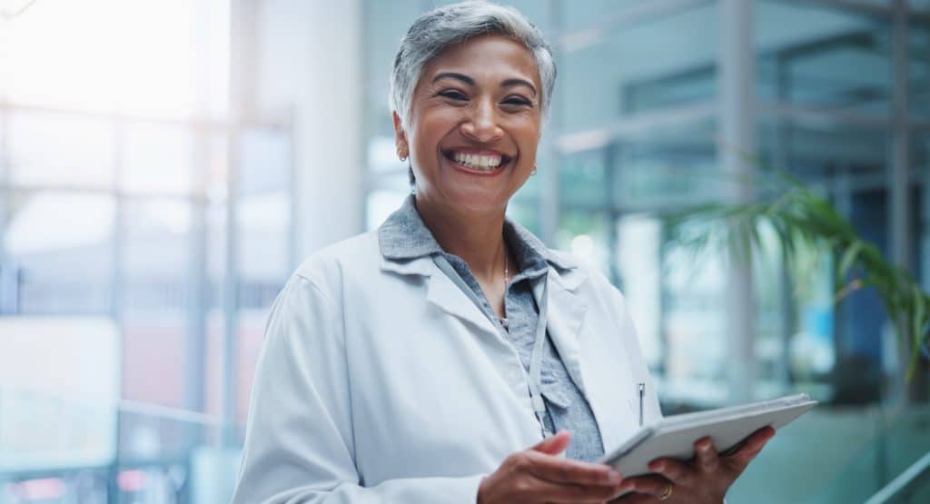 Smiling doctor holding a tablet in a clinic