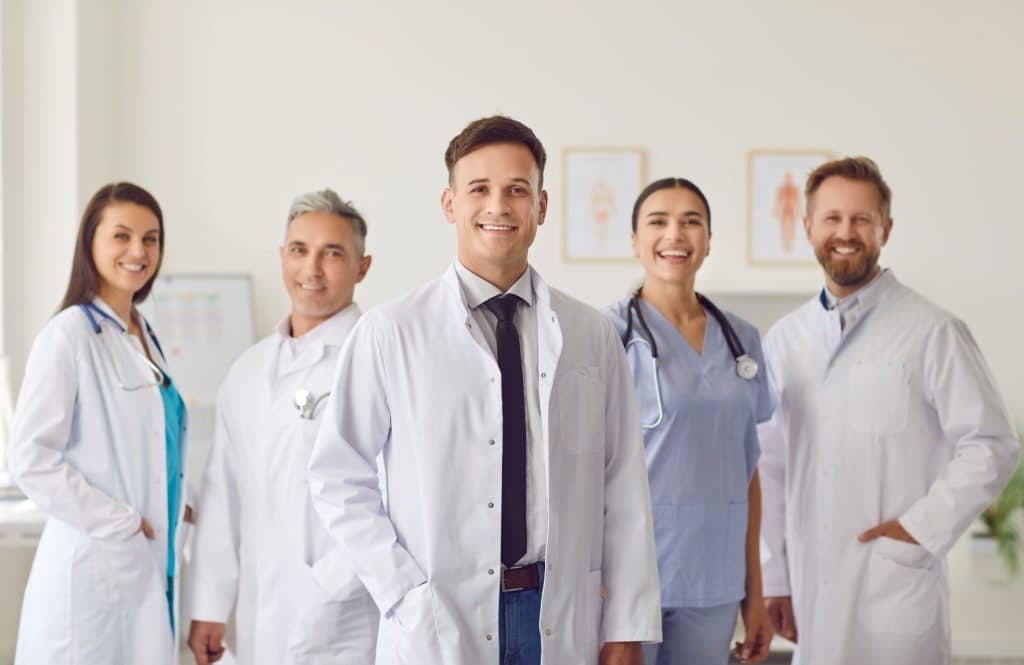 Team of smiling doctors in white coats
